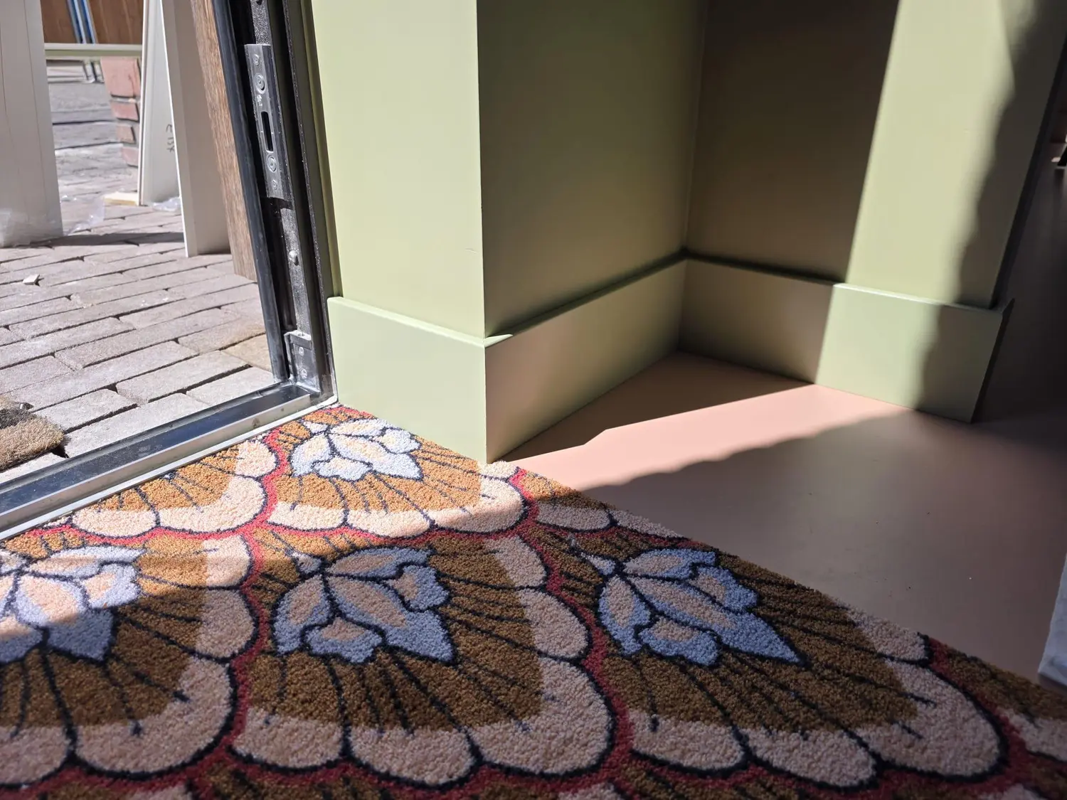 Groene maatwerkplint bij uitgesproken behang — doorlopende plintlijn